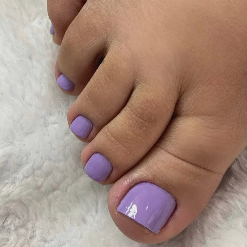 Esmalte roxo nas unhas dos pés